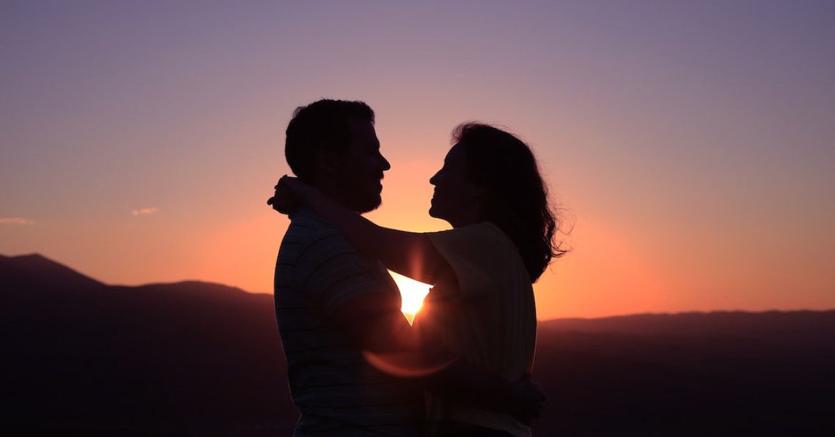 "Diverse lesbian couple embracing, love quotes backdrop."